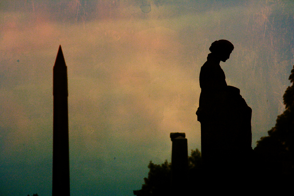 Silhouettes of cemetary statue and obelisk
