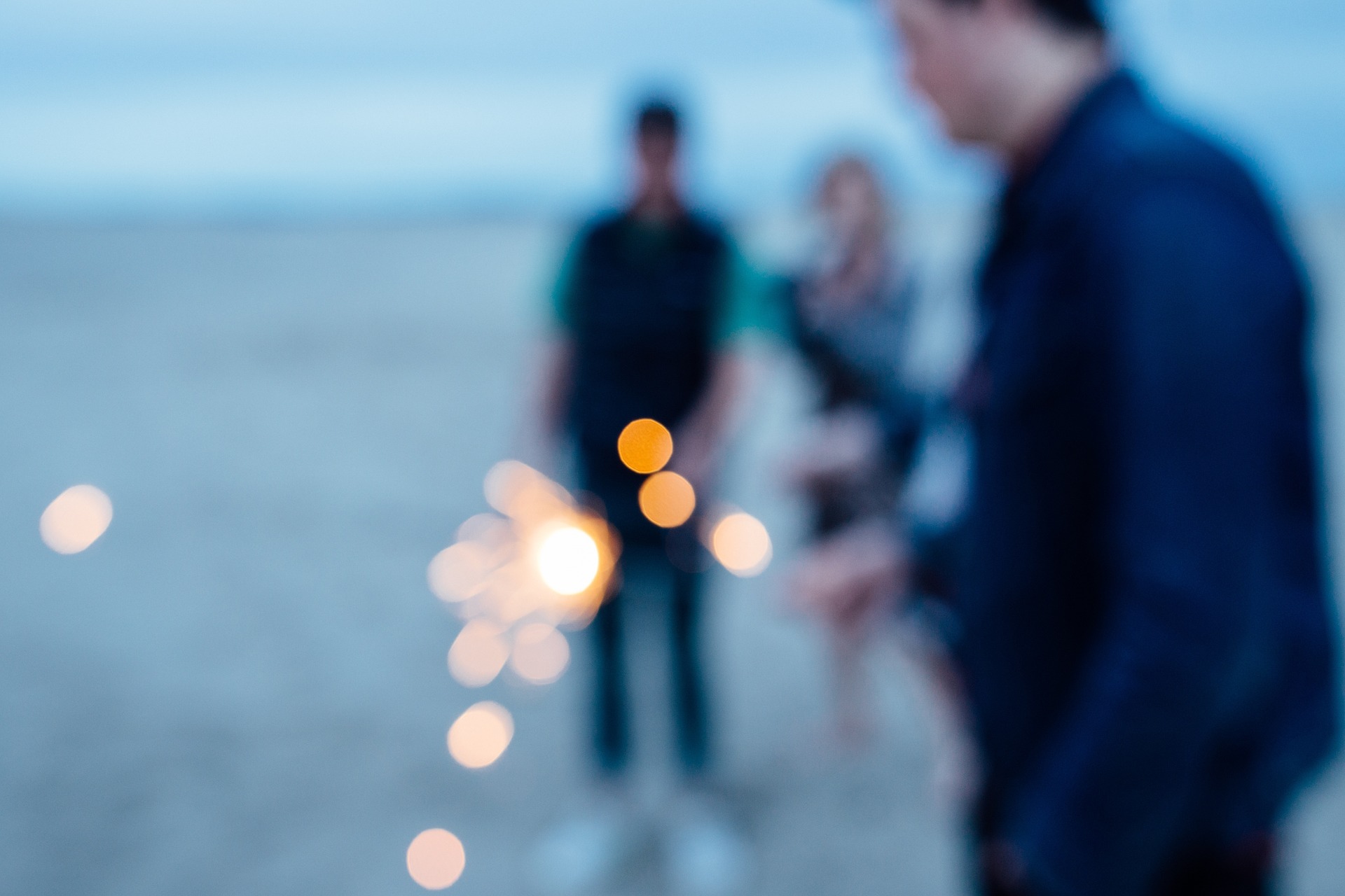 Blurry picture of people with sparklers.