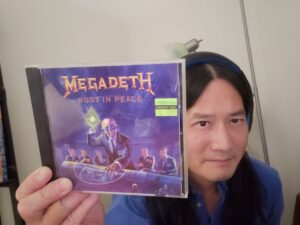 Image of staff (Young) with CD of Rust in Peace