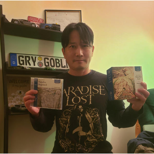 Image of staff Librarian (Young) holding two audiobook cds: Paradise Regained and Paradise Lost, narrated by Anton Lesser