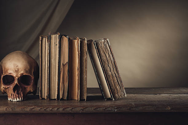 Ancient books and human skull on a wooden table, knowledge and wisdom concept