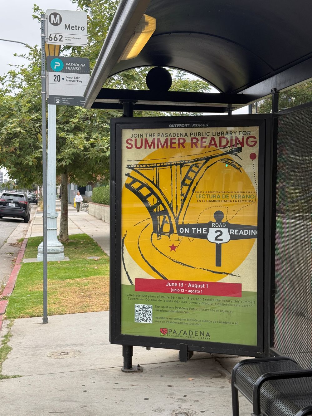 Bus shelter advertisement for Summer Reading 2026, titled “On the Road to Reading."