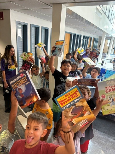 Group of children holding up books
