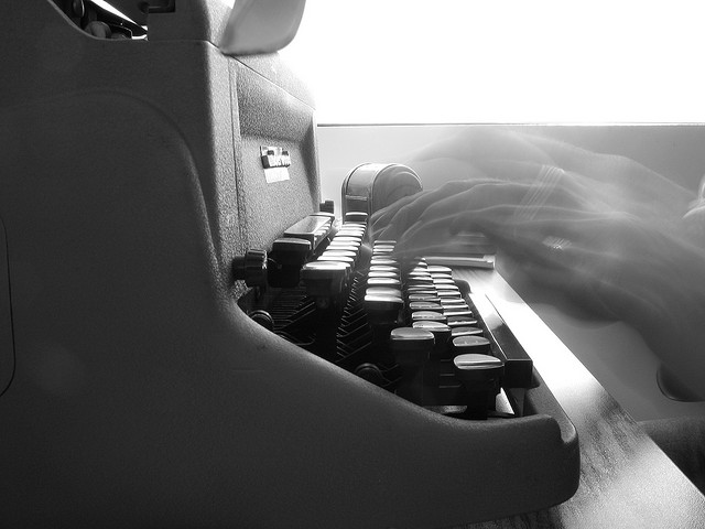 Hand blurred typing on a typewriter